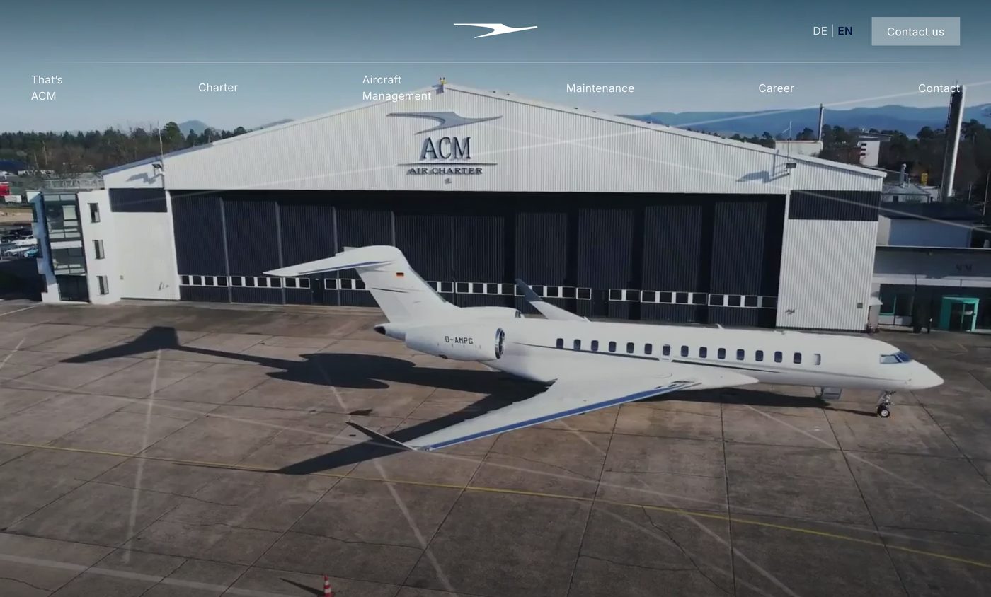 Englische Startseite von acm.aero heute: Video vom ACM Hangar am Baden Airpark, Navigation mit Charter, Aircraft Management, Maintenance und Career, Umschalter für Deutsch und Englisch