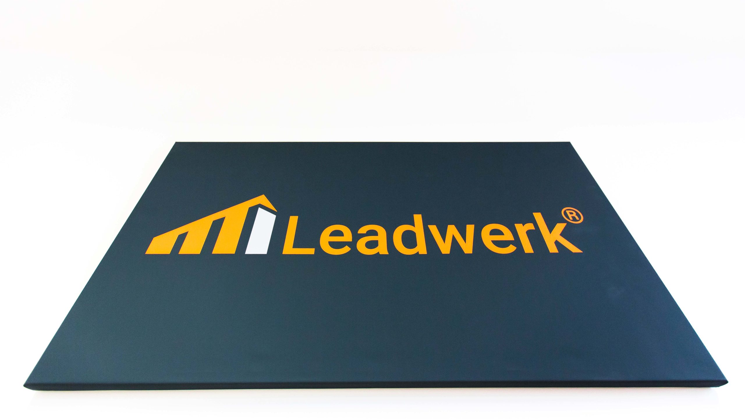 Logo von Leadwerk in orange auf schwarzem Hintergrund, symbolisiert Wachstum und Innovation im Bauwesen.